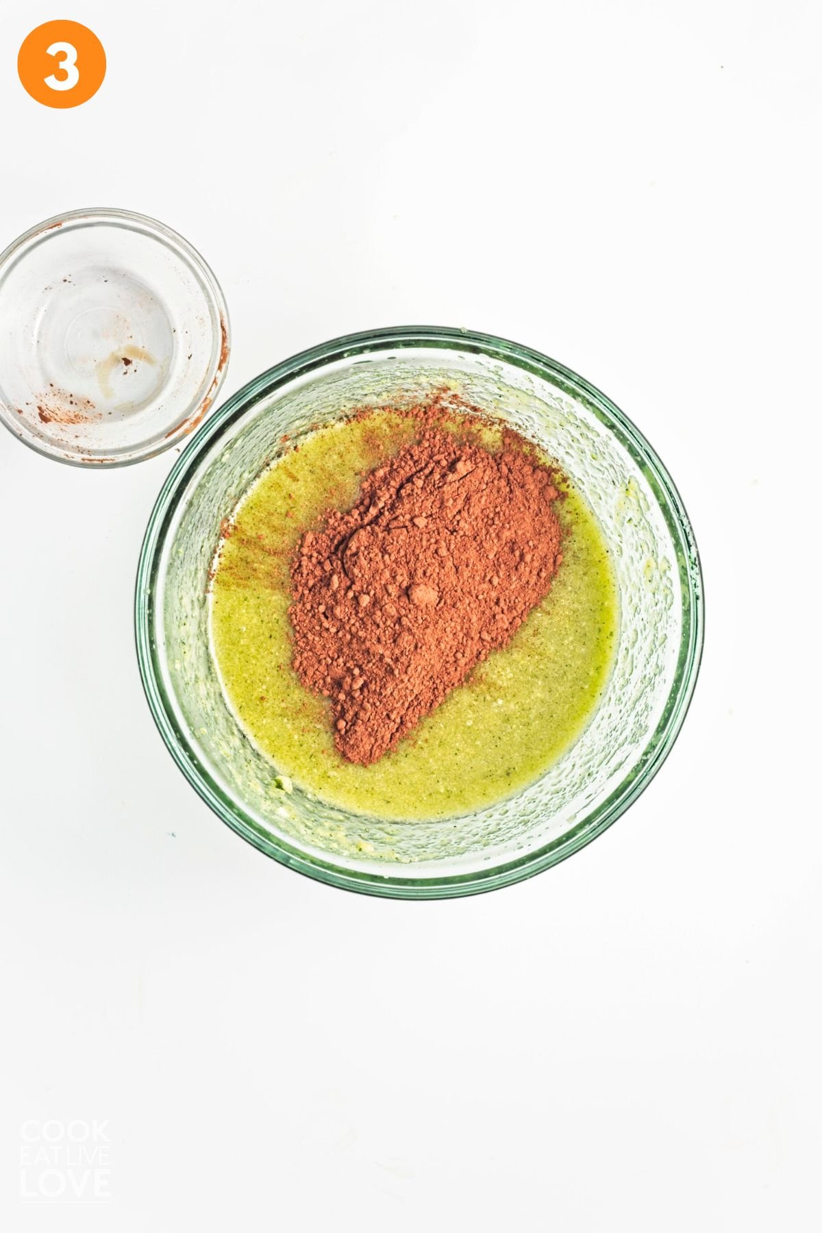 Cocoa powder added to  the zucchini mixture in a bowl.