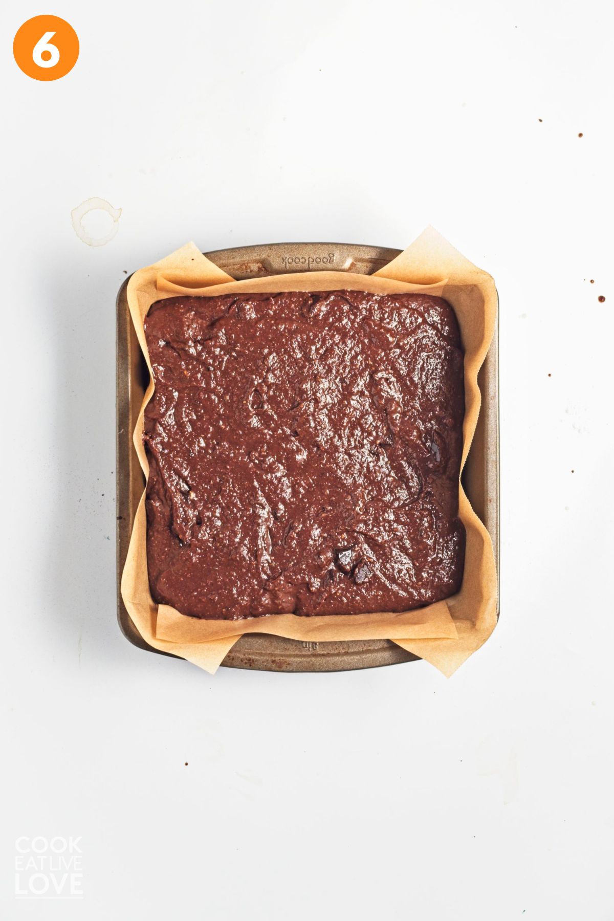 Zucchini brownie batter added to a parchment lined baking dish.