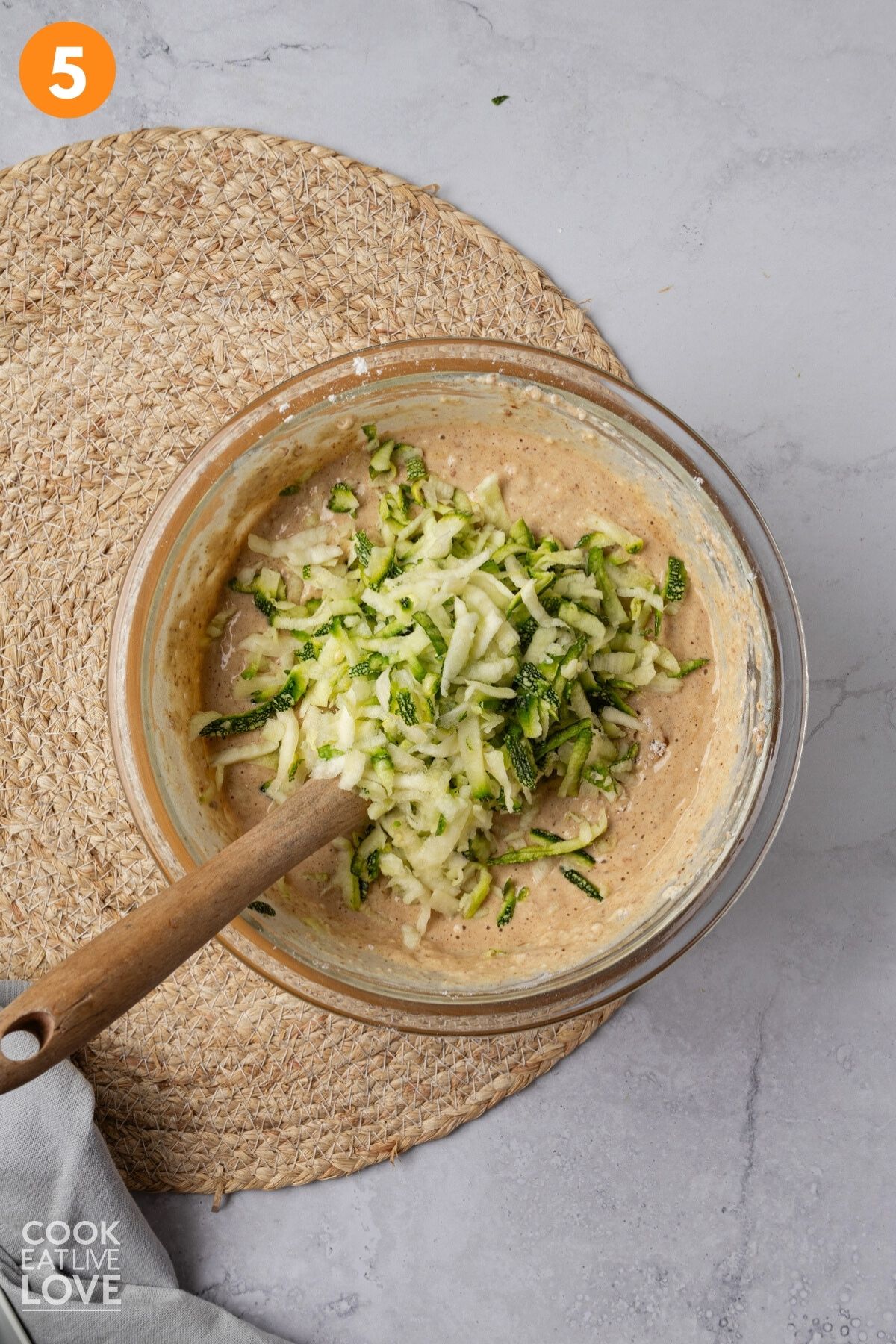 Squeezed zucchini added to the bowl of pancake batter.