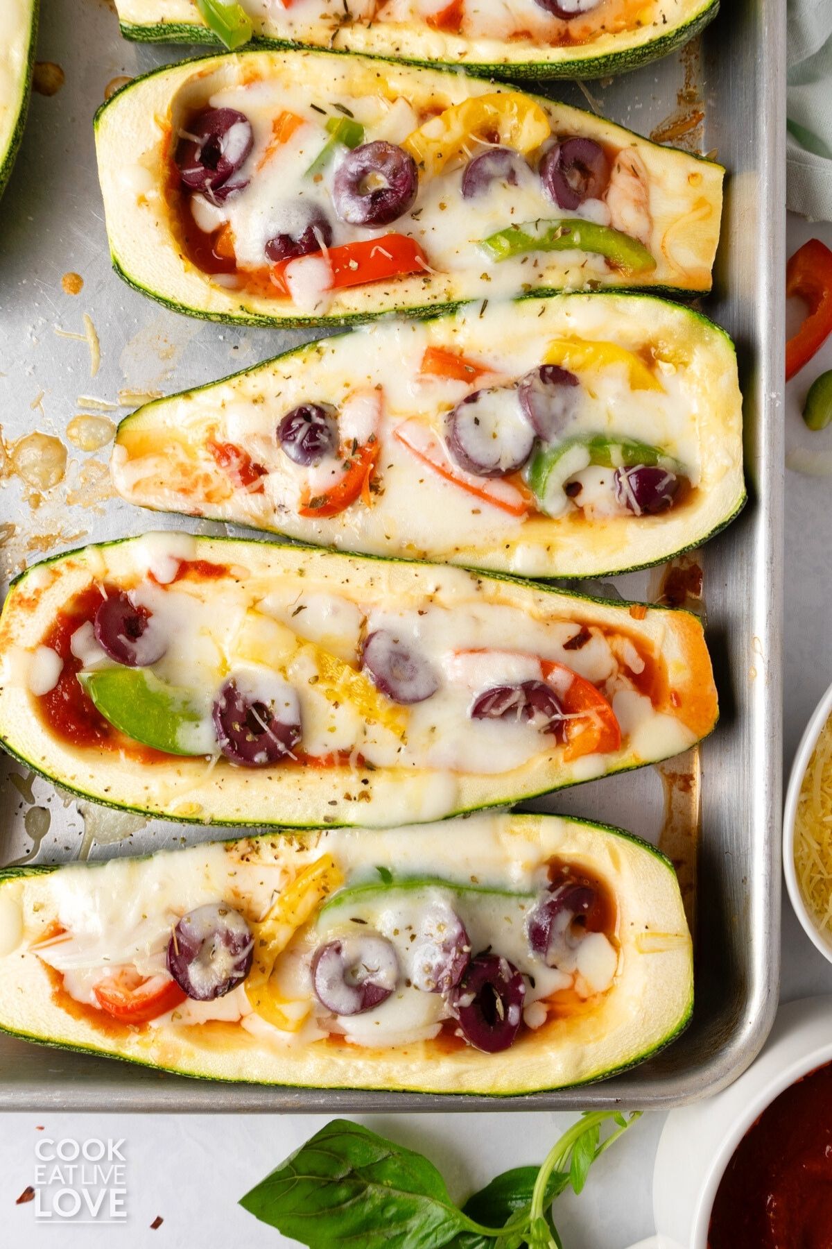 Vegetable pizza boats on a baking tray.