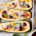 Zucchini pizza boats on a baking sheet pan.