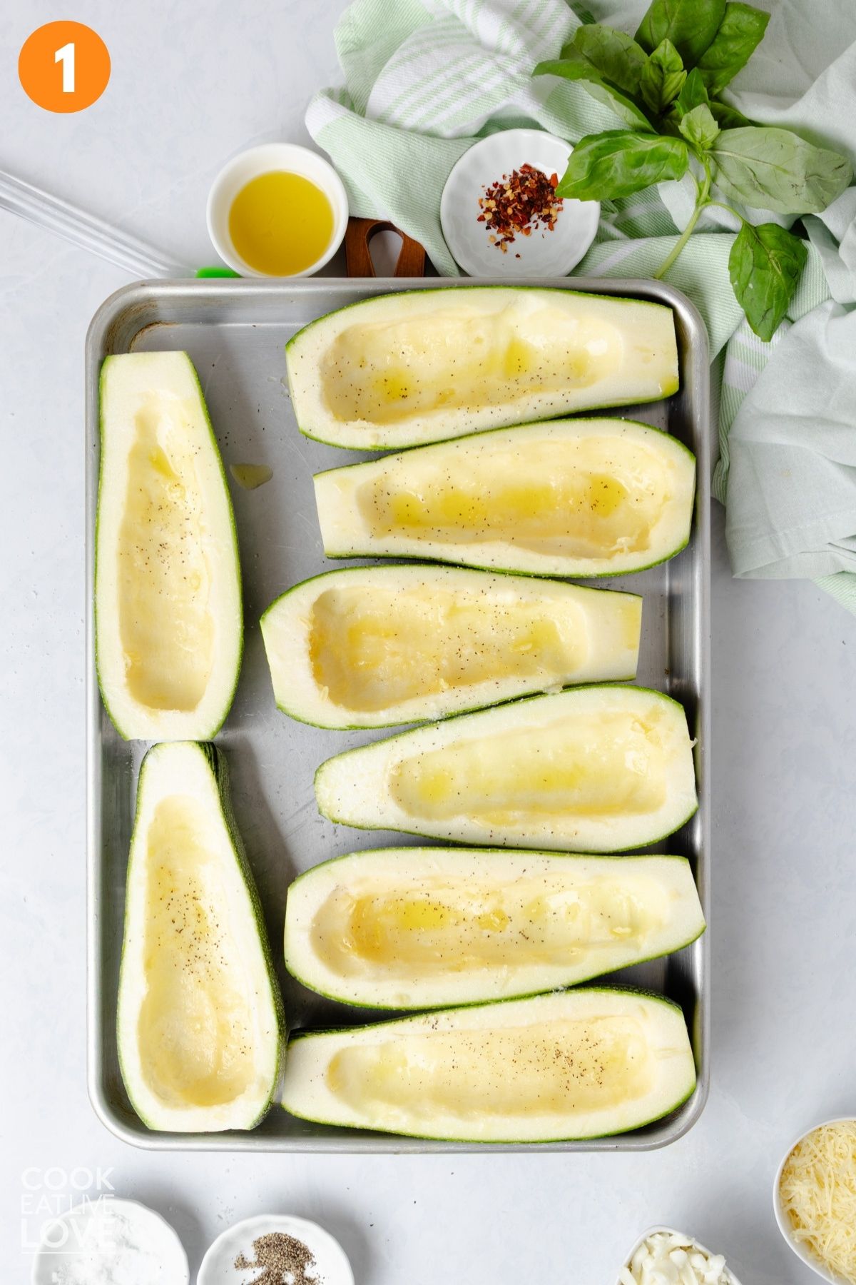 Scooped out zucchini laying on a baking sheet pan.