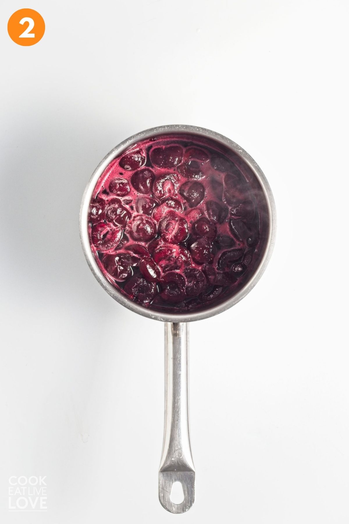 Cherry compote cooking in a saucepan.