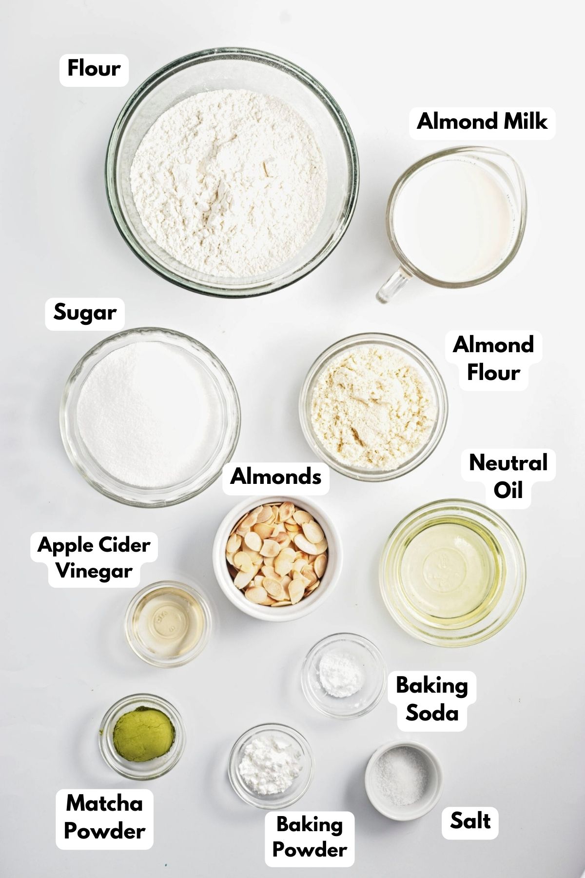 Ingredients to make matcha muffins in bowls on the counter. 