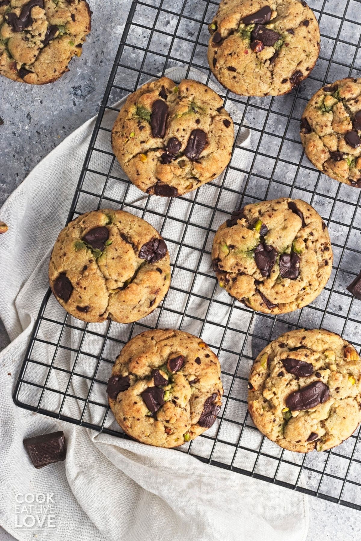 Pistachio chocolate chip cookies are cooling on a wire rack.