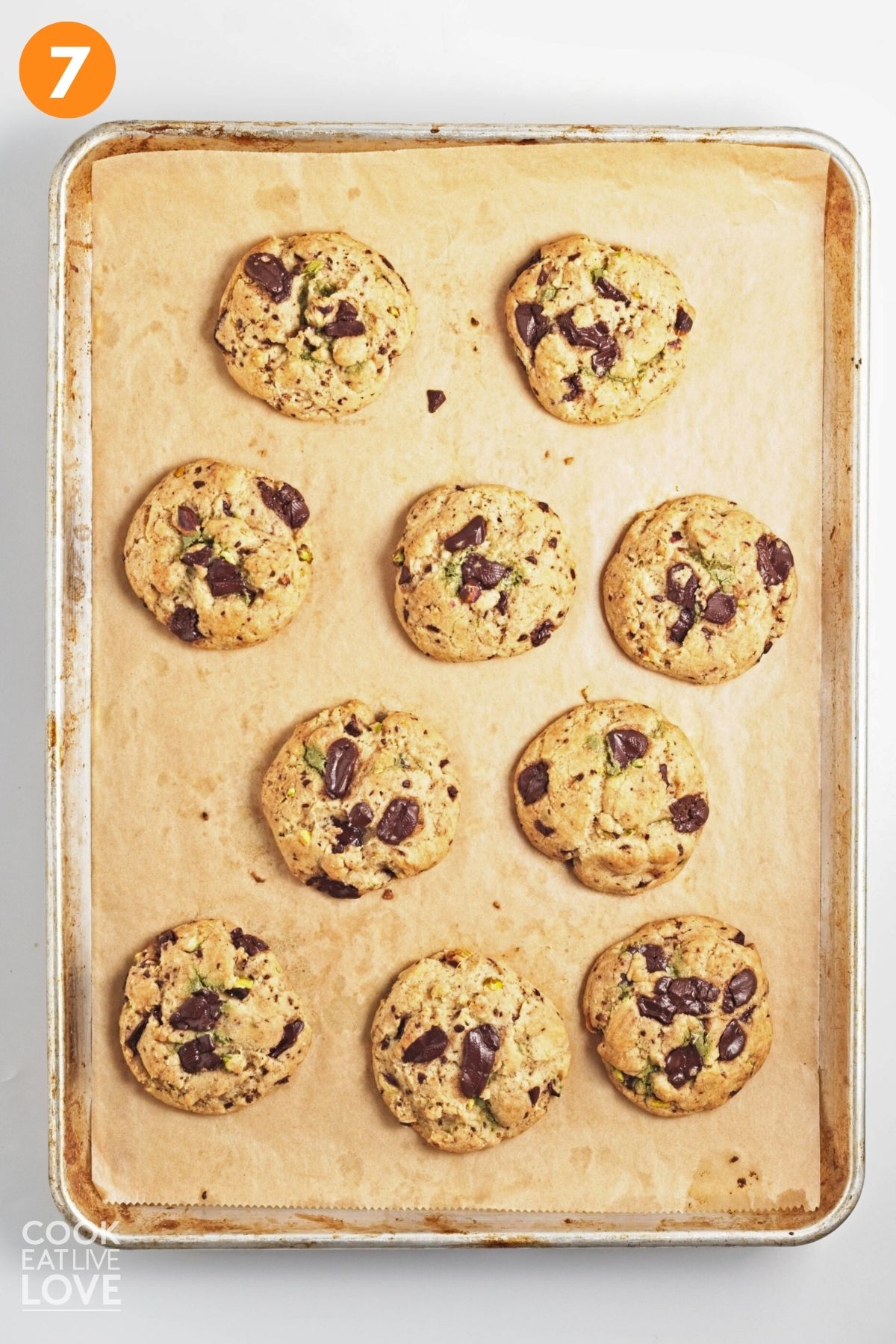 Baked pistachio chocolate chunk cookies on the pan.