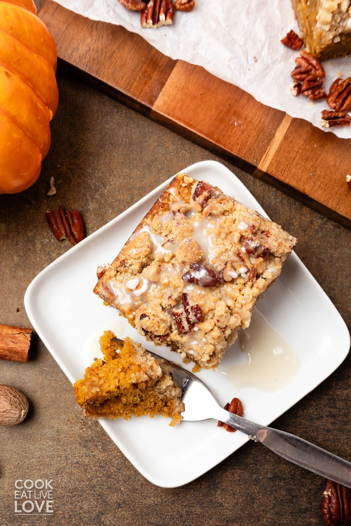 Pumpkin coffee cake with streusel with a fork resting to the side holding a bite. 