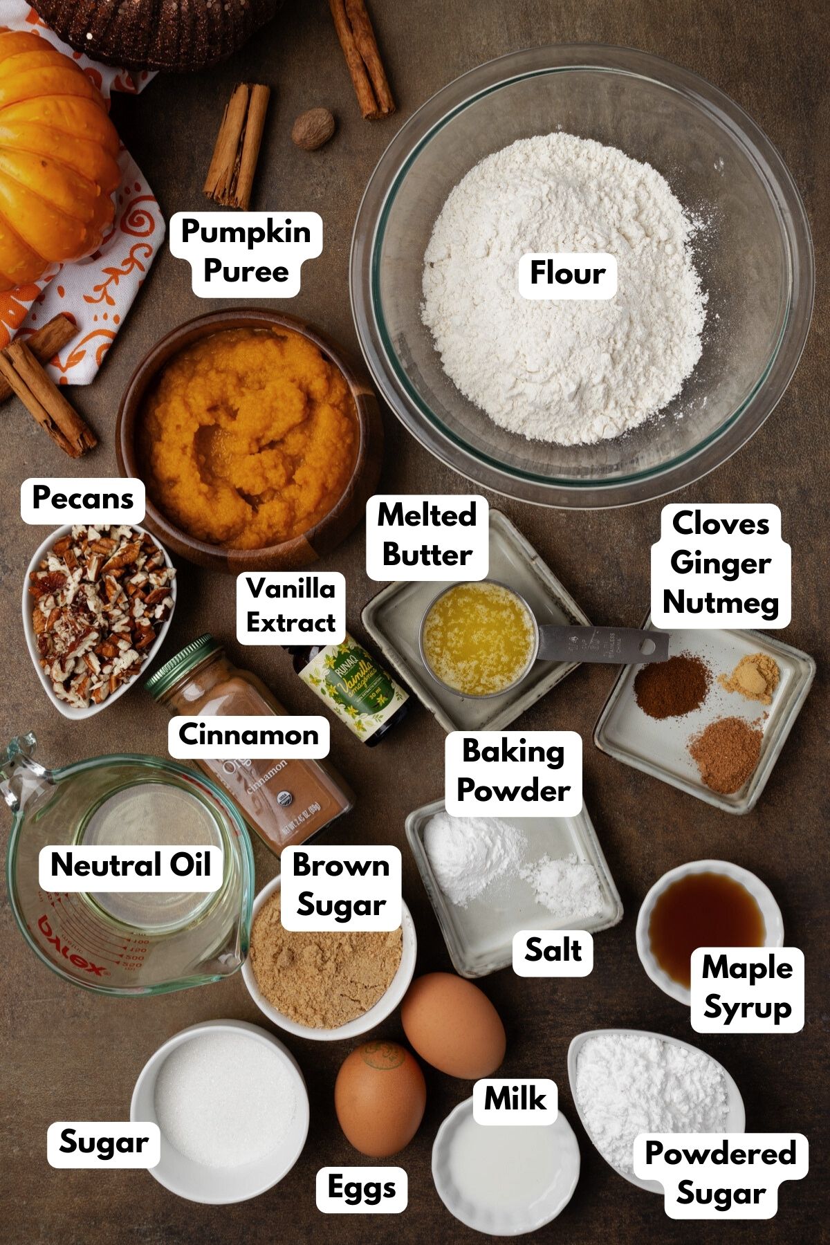 Ingredients to make pumpkin coffee cake on the table in bowls with labels. 
