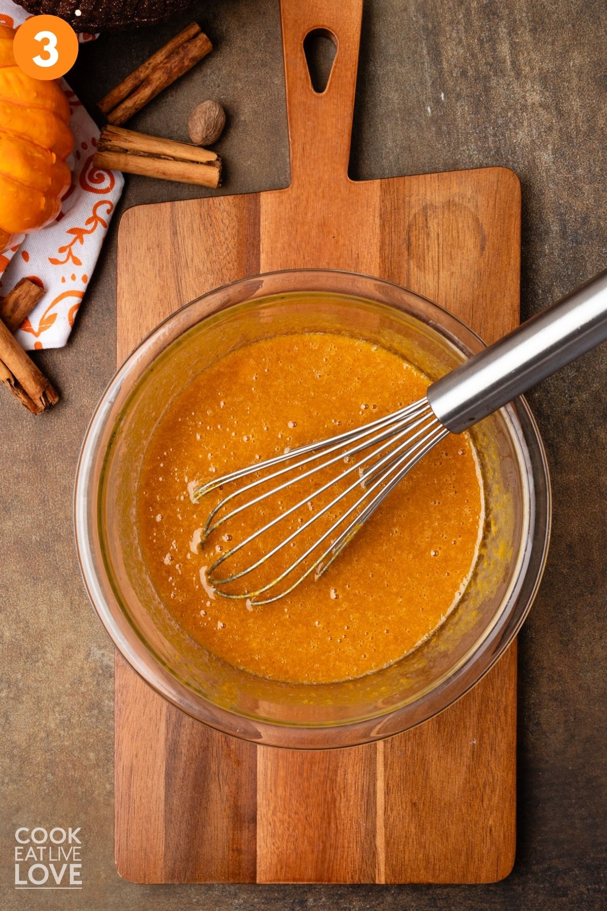 Eggs, pumpkin, and other liquid ingredients mixed together in a bowl.