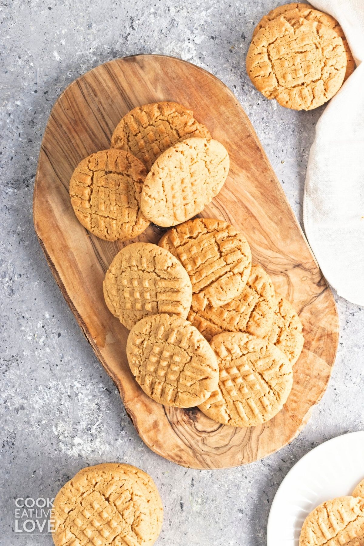 Peanut butter cookies without eggs piled up on a wooden board. 