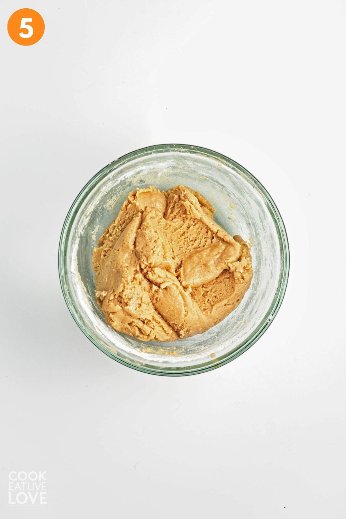 Vegan peanut butter cookie dough mixed in a clear mixing bowl.