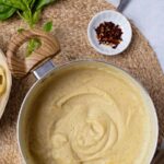 Pinterest graphic with image of vegan alfredo sauce and text on top.