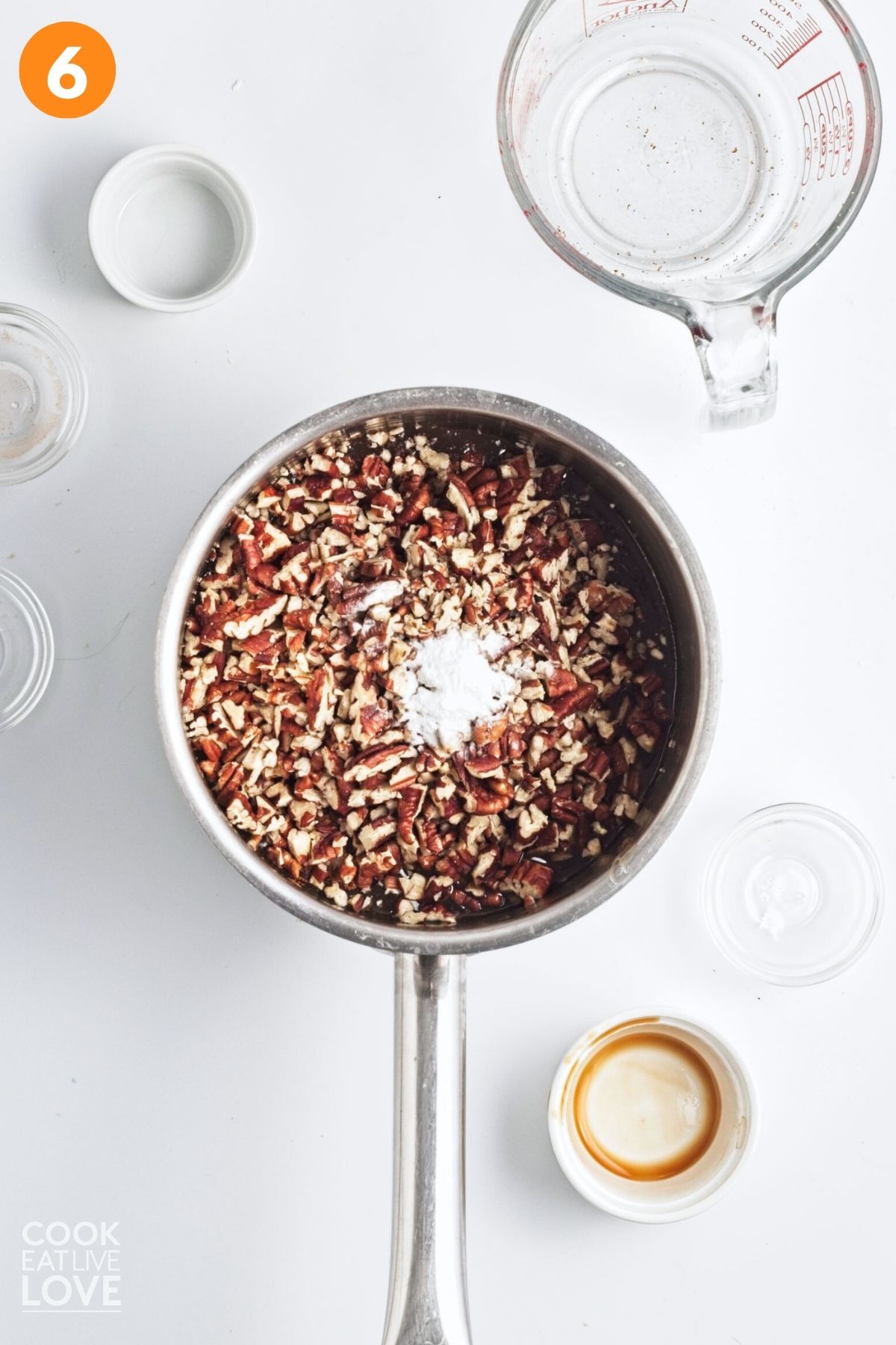 Pecans, spices, and baking soda added to the pot of caramel sauce.