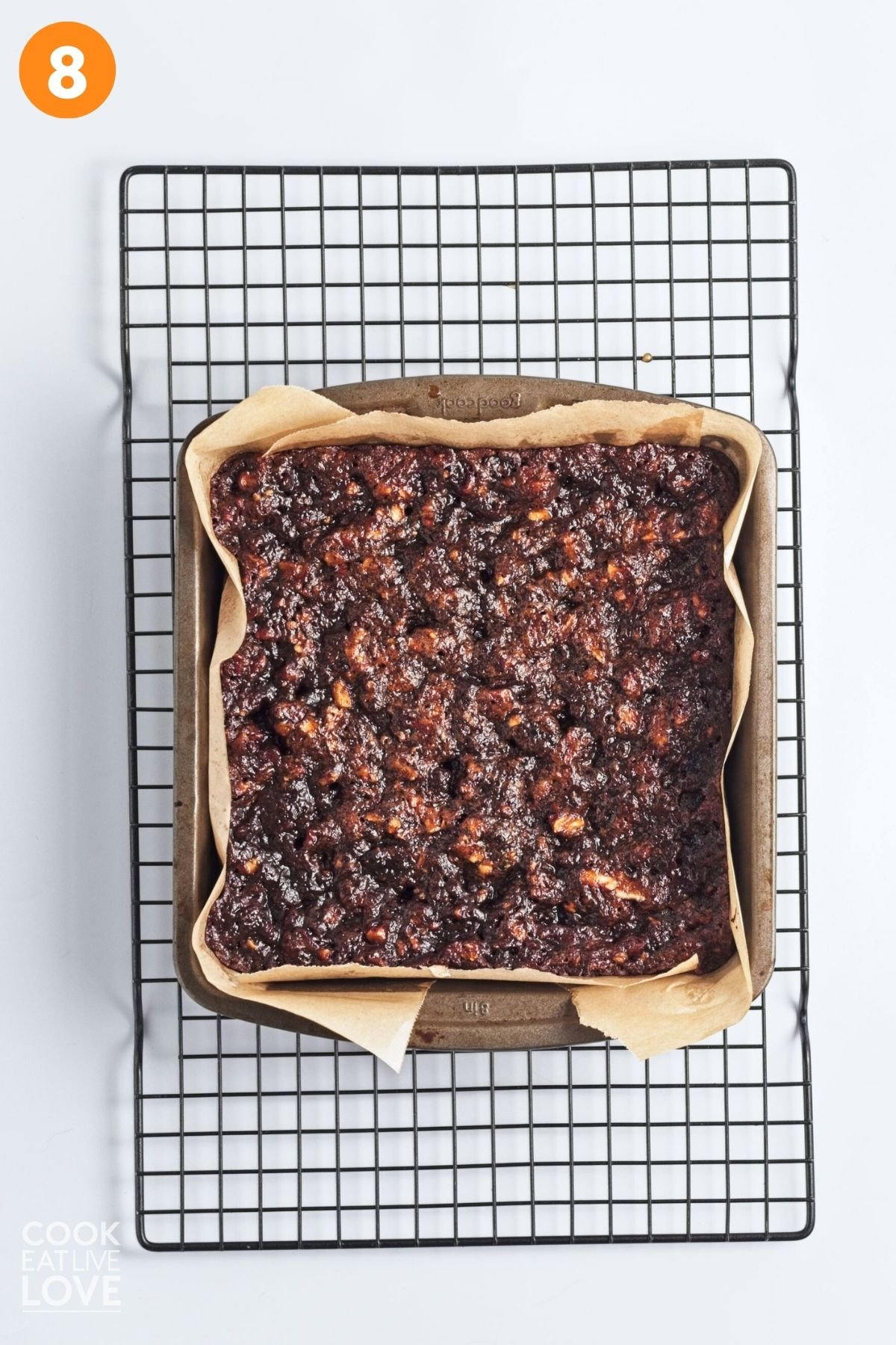 Vegan pecan bars in a pan on a cooling rack.