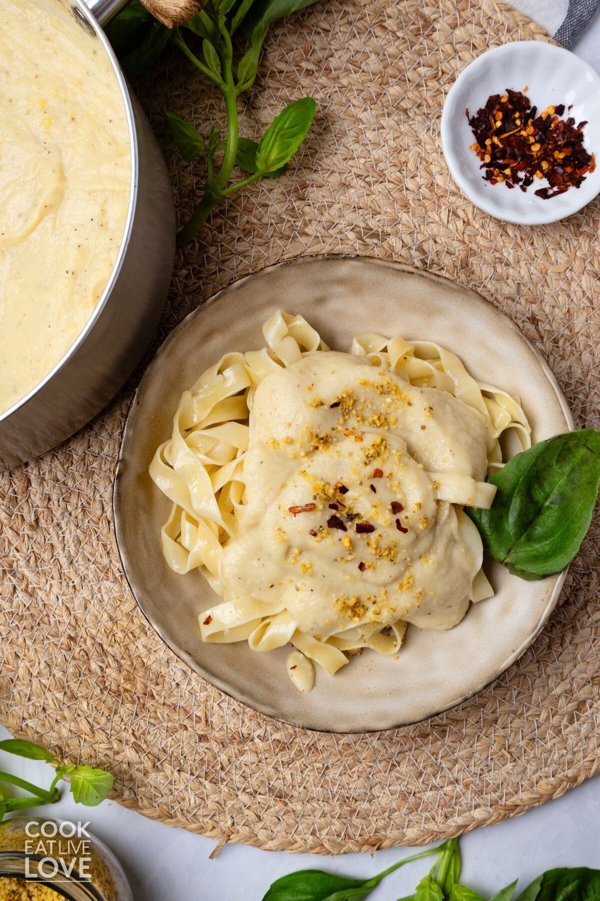 Vegan alfredo sauce on top of a plate of fettuccine. 