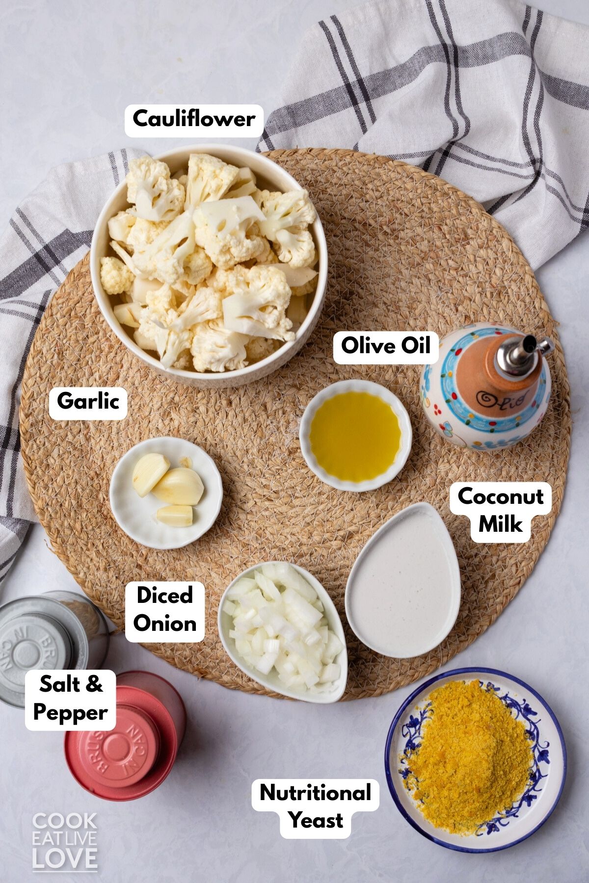 Ingredients to make vegan alfredo sauce on the table in bowls with labels. 