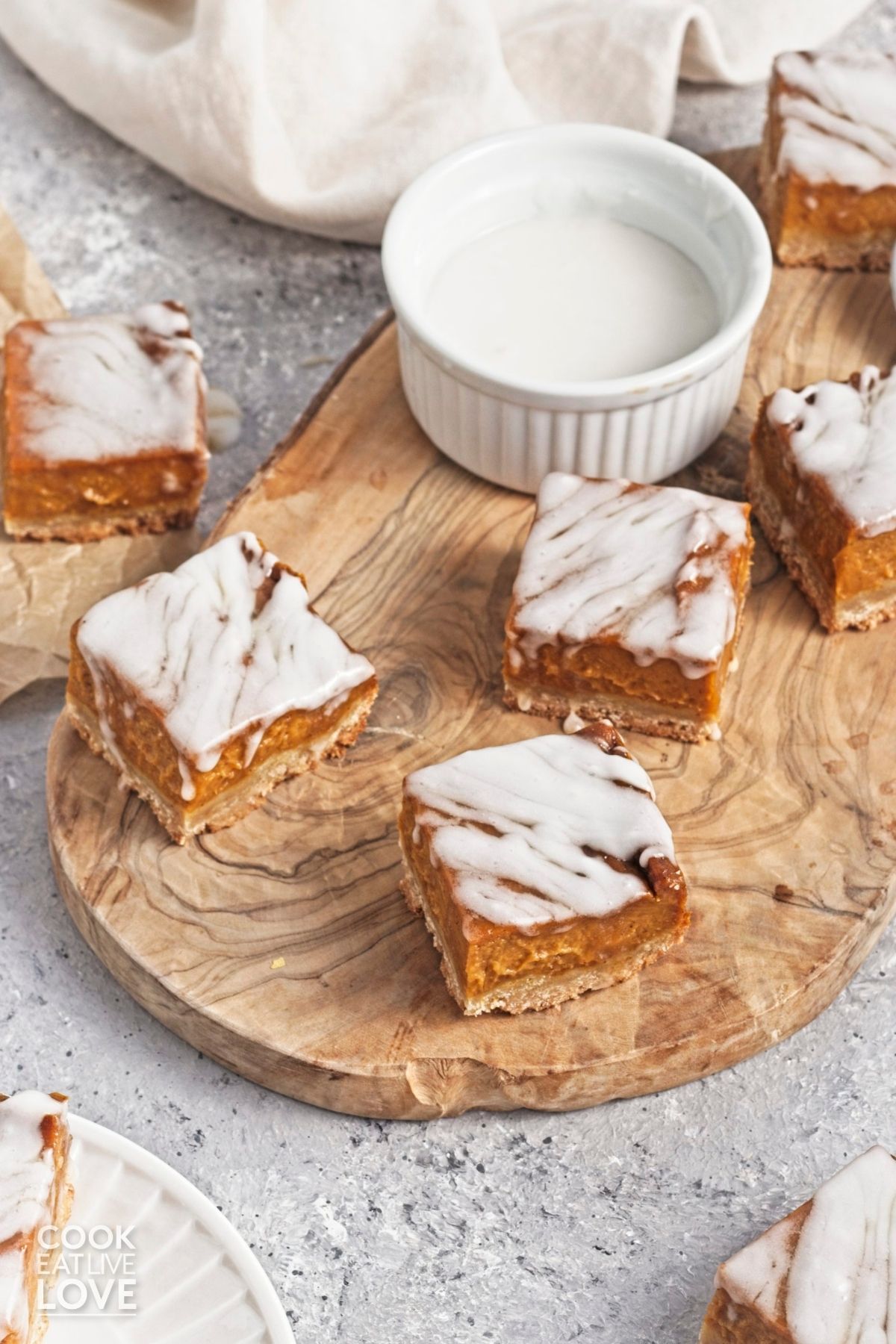 Three vegan pumpkin bars arranged on a wooden cutting board.