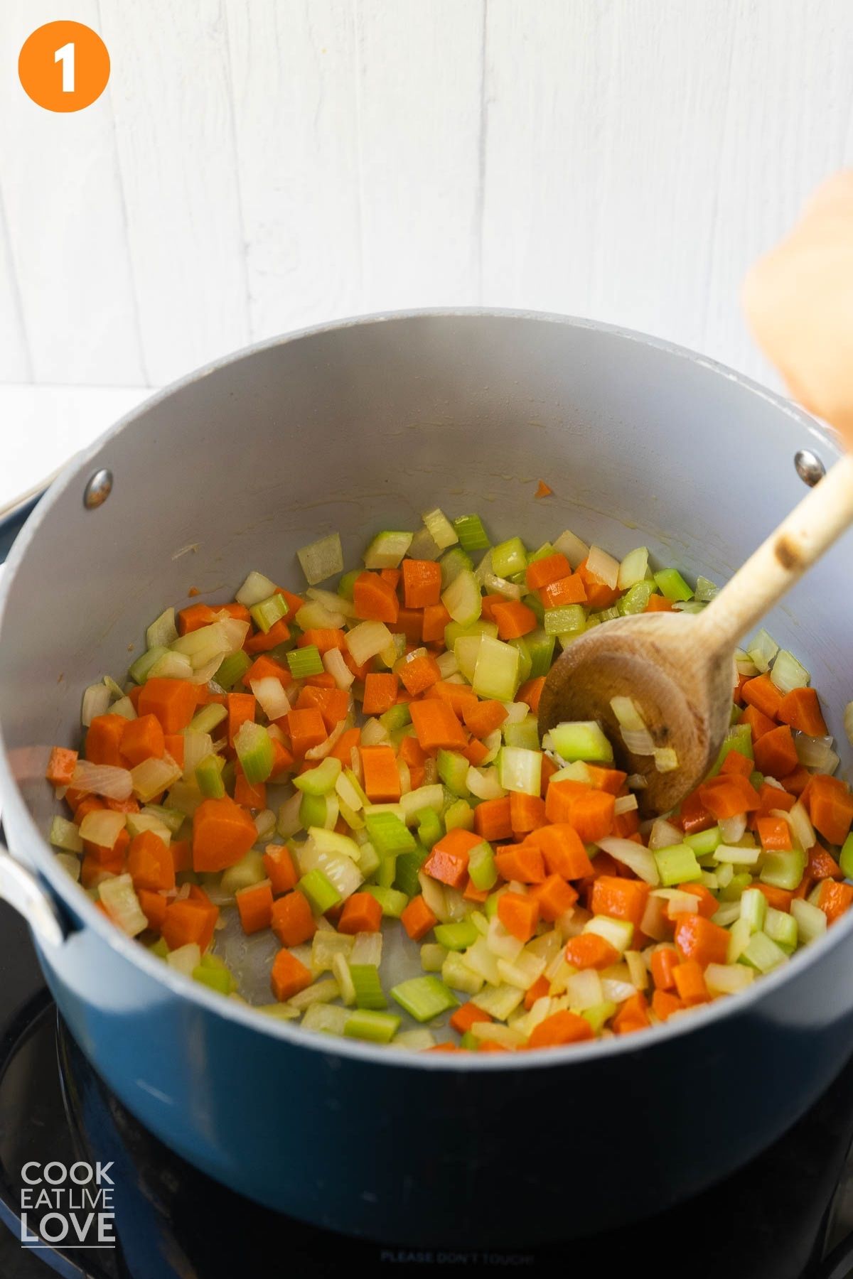 Carrots, celery, and onion cooking in a pot.