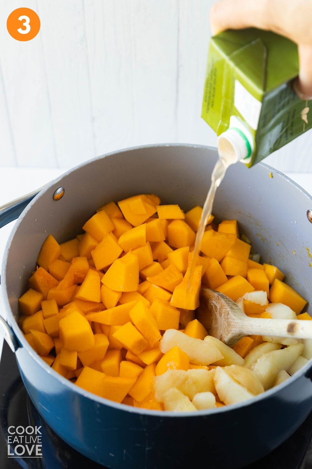 Butternut squash added to the pot and pouring broth into it.