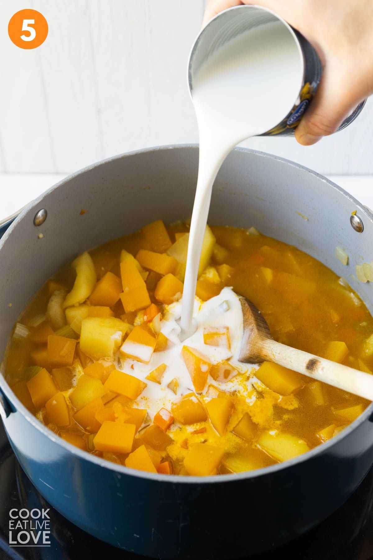 Adding the coconut milk to the pot.