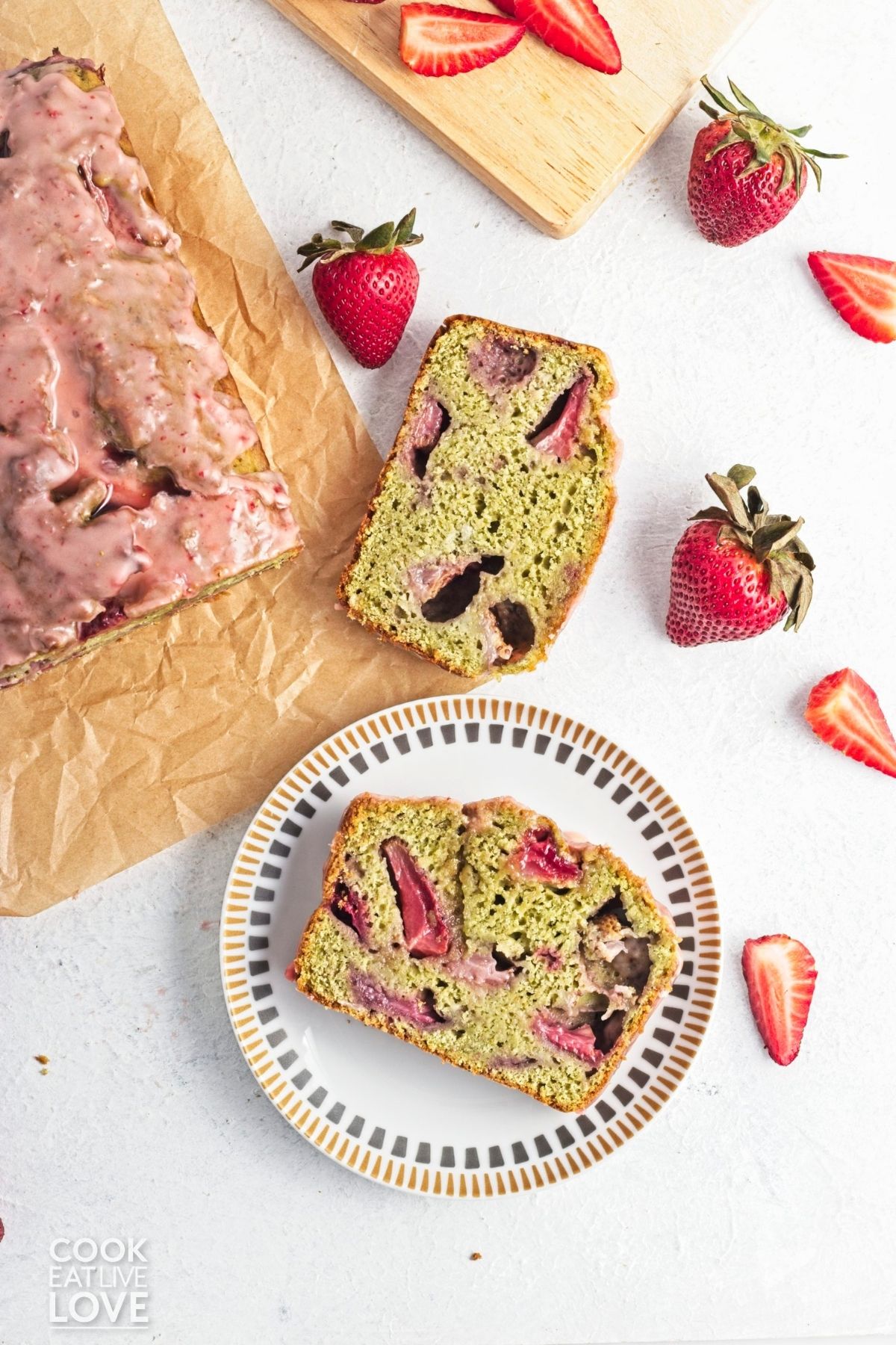 A slice of matcha banana bread on a plate with strawberries. 