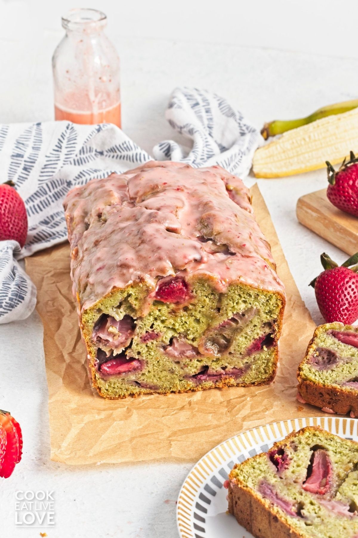 A loaf of matcha banana bread with a pink strawberry glaze on top. 