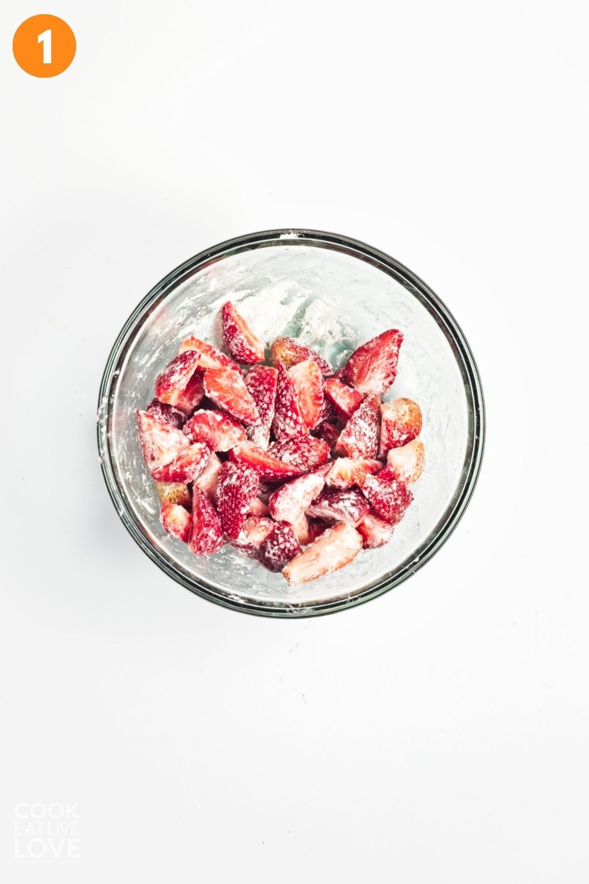 Strawberries tossed with flour in a bowl. 