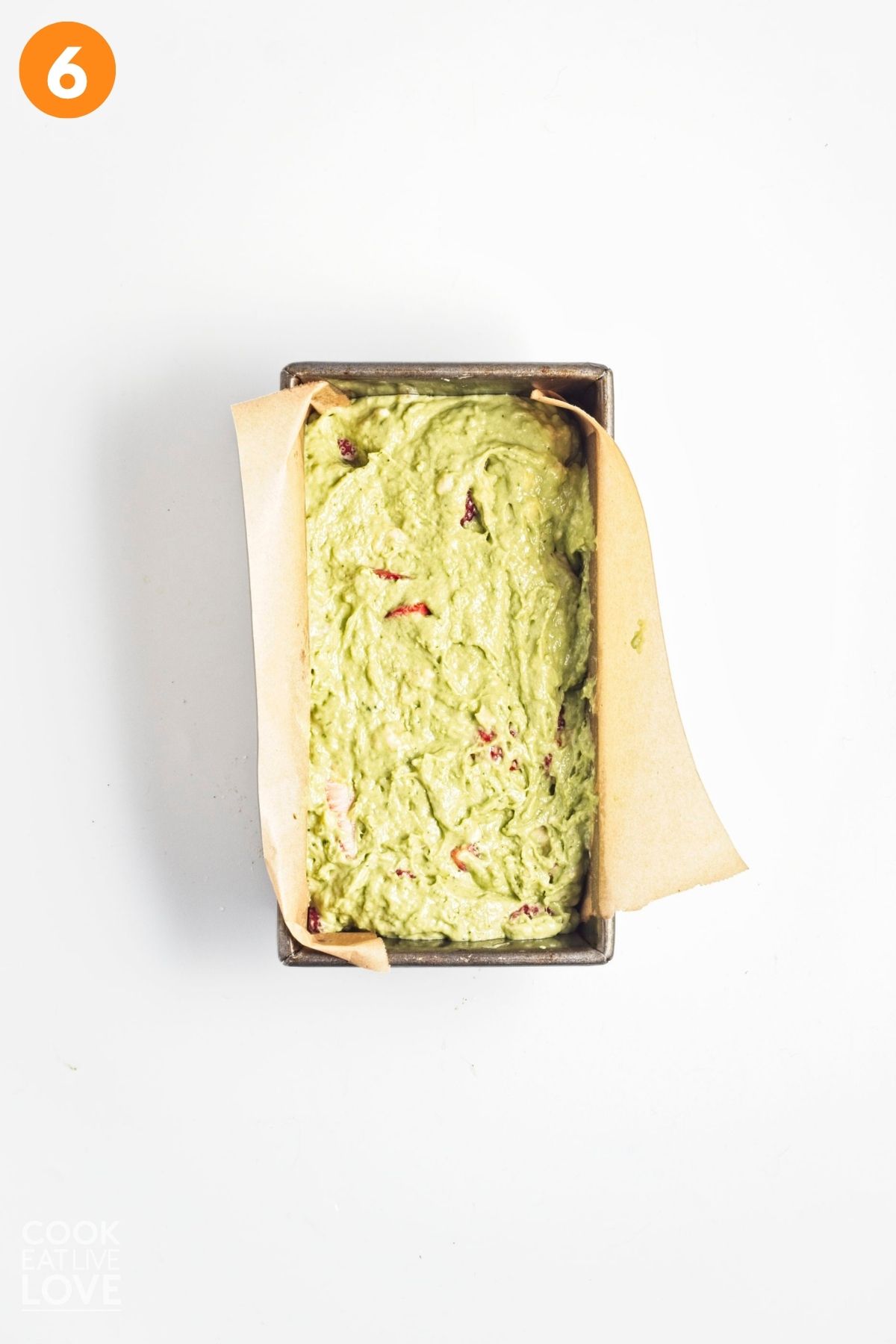 Matcha banana bread batter added to a parchment lined pan. 