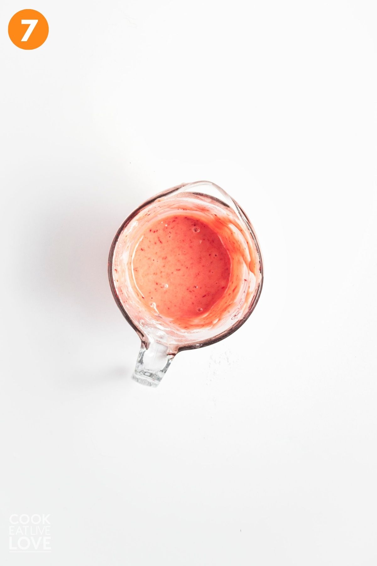 Strawberry glaze in a glass measuring cup. 