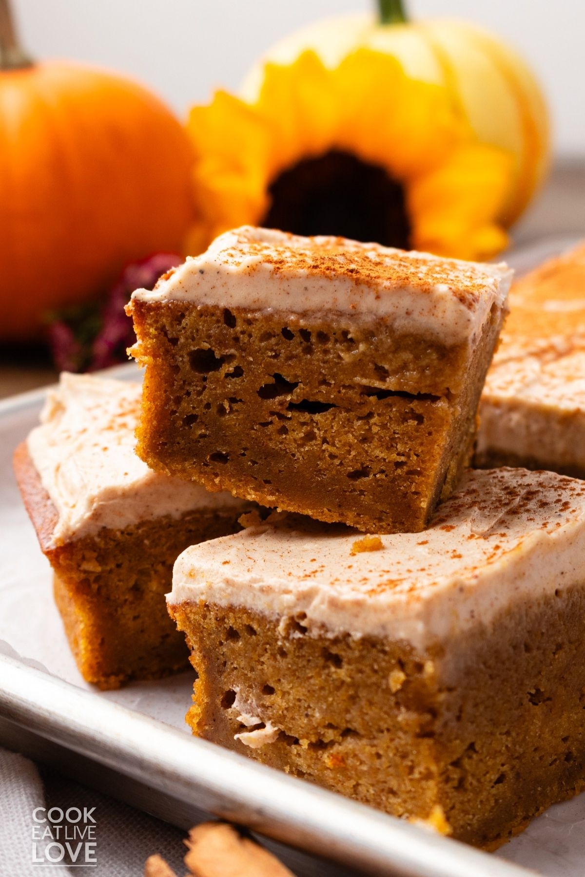 Squares of pumpkin sheet cake stacked on each other. 