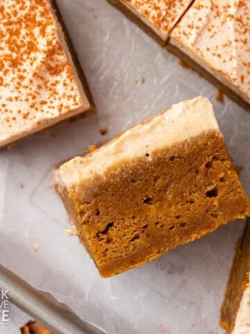 Slices of pumpkin sheet cake in different angles on a baking sheet.