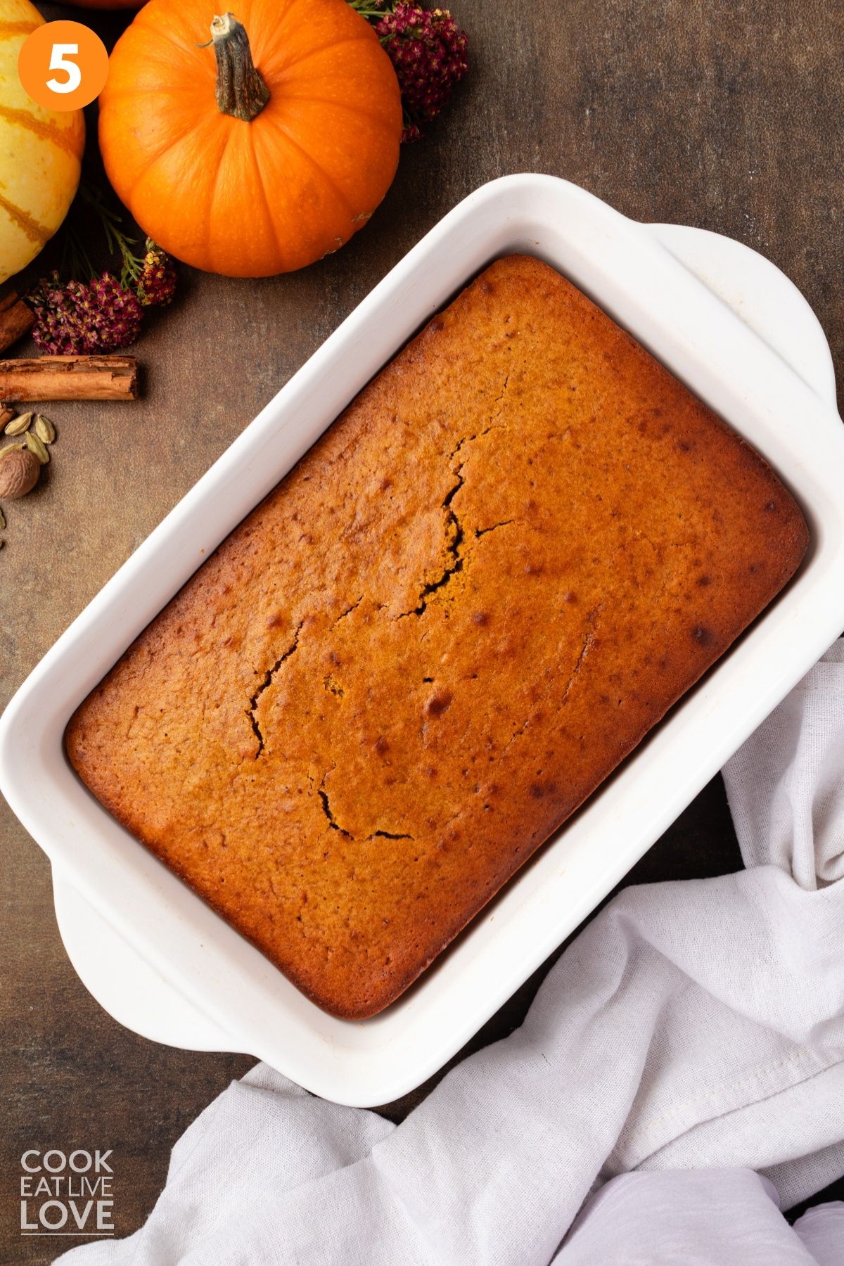 Baked cake in a white ceramic baking dish.