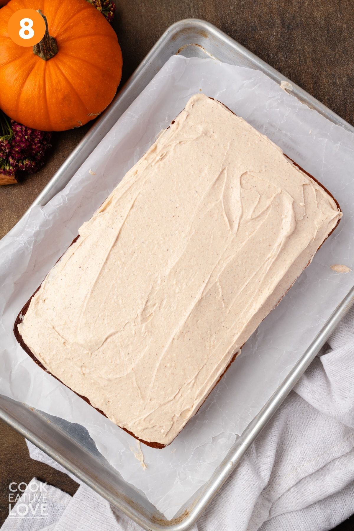 Frosted pumpkin sheet cake on a pan. 