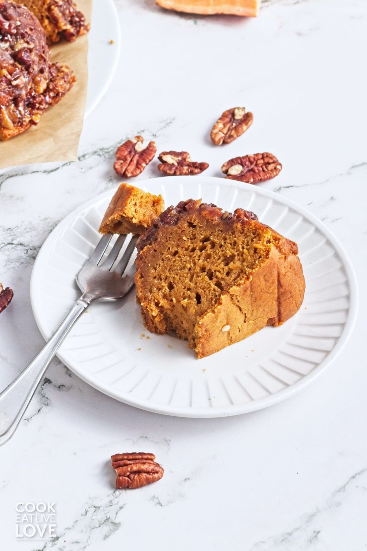 A slice of sweet potato cake with a bite on a fork resting to the side. 