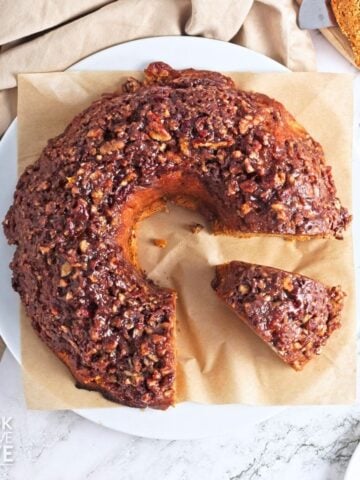 Sweet potato cake with pecan topping on a piece of parchment.