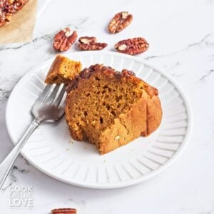 A slice of sweet potato cake on a plate with a bite resting on a fork.