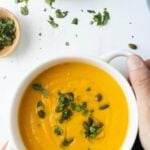 Pinterest graphic with image of butternut squash soup with coconut milk and text on top.