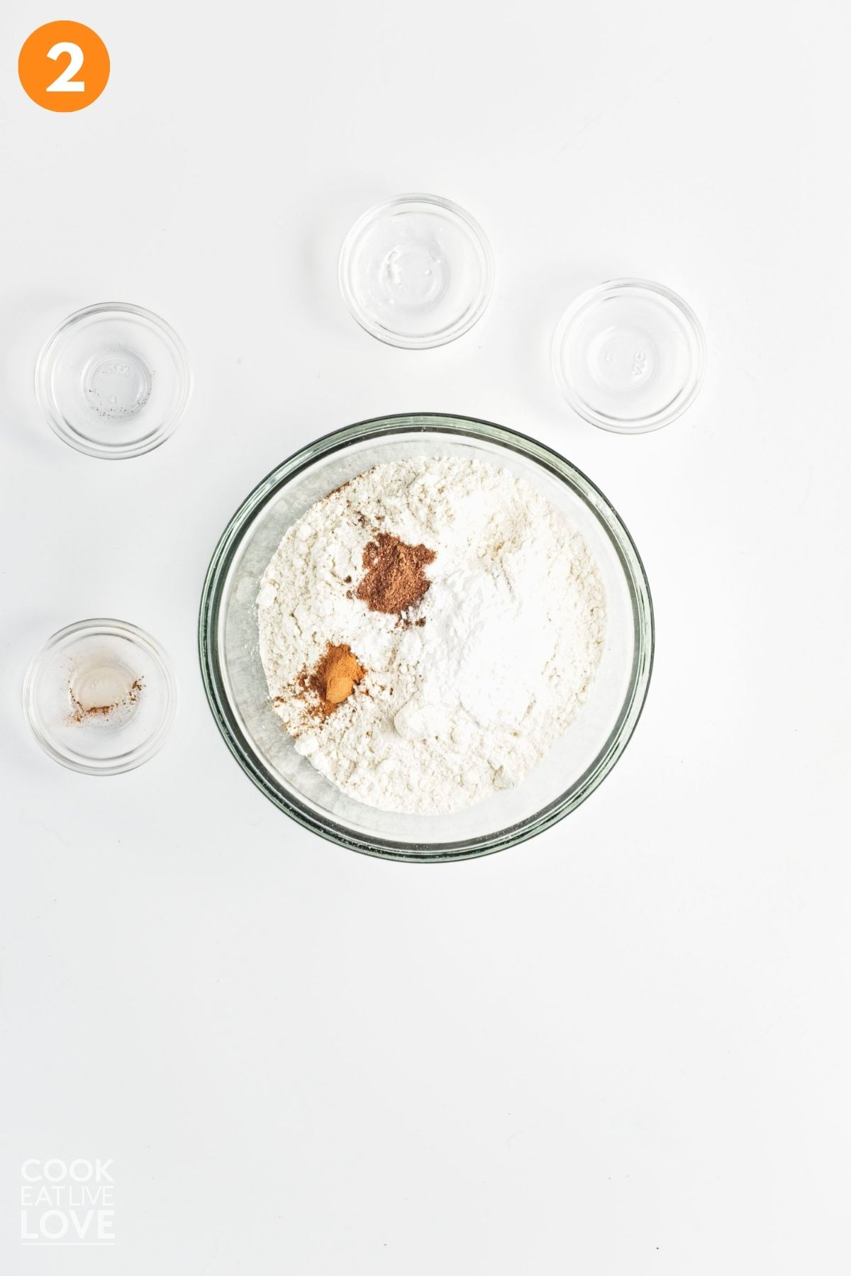 Flour, spices, and other dry ingredients added to a bowl. 