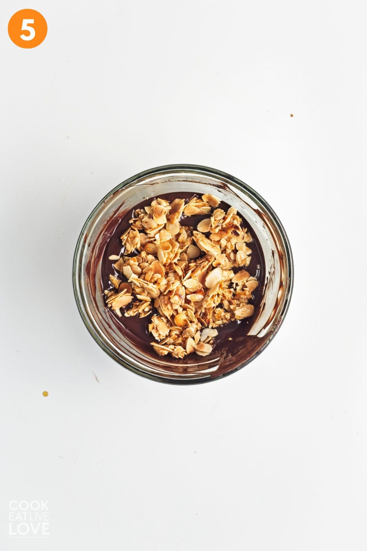 Almonds are added to the bowl of melted chocolate. 