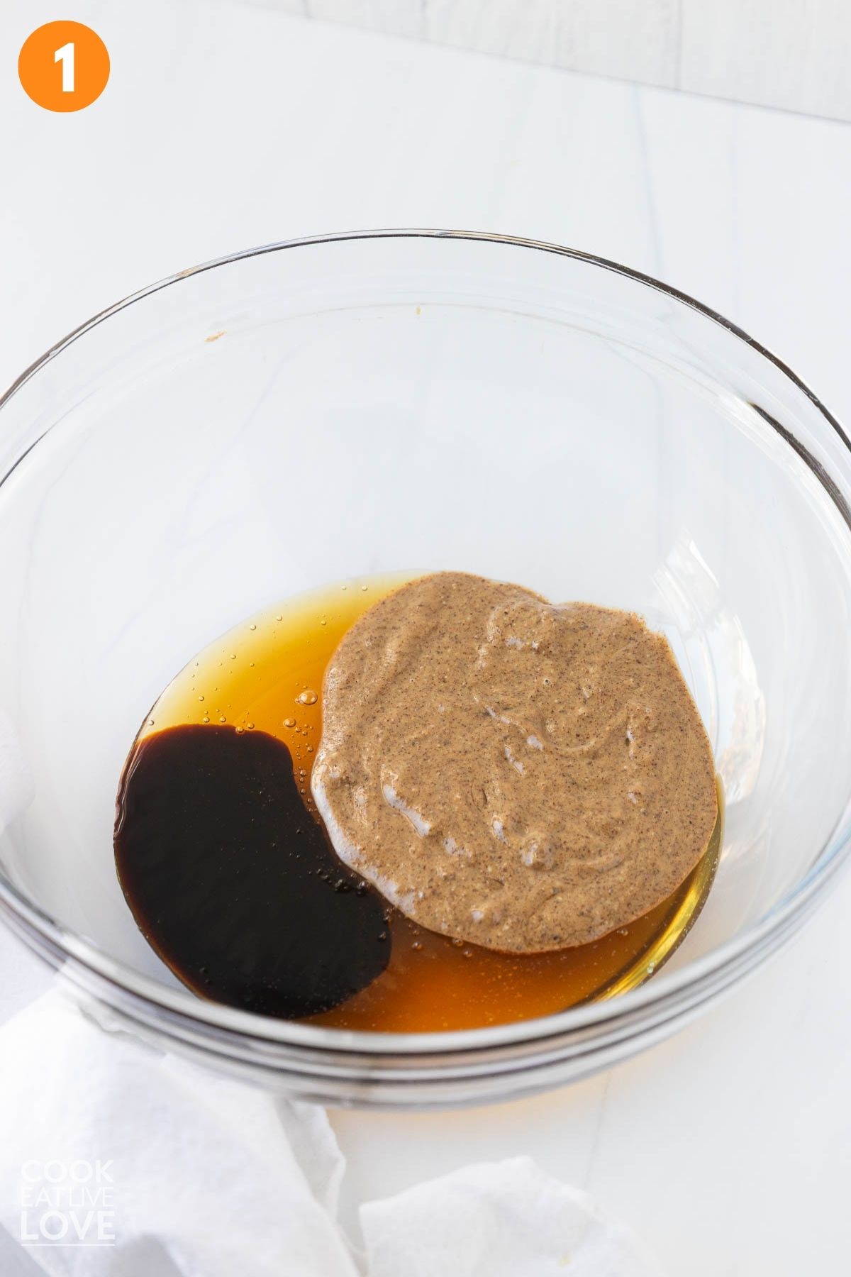 Almond butter, honey, molasses, and vanilla extract in a bowl.