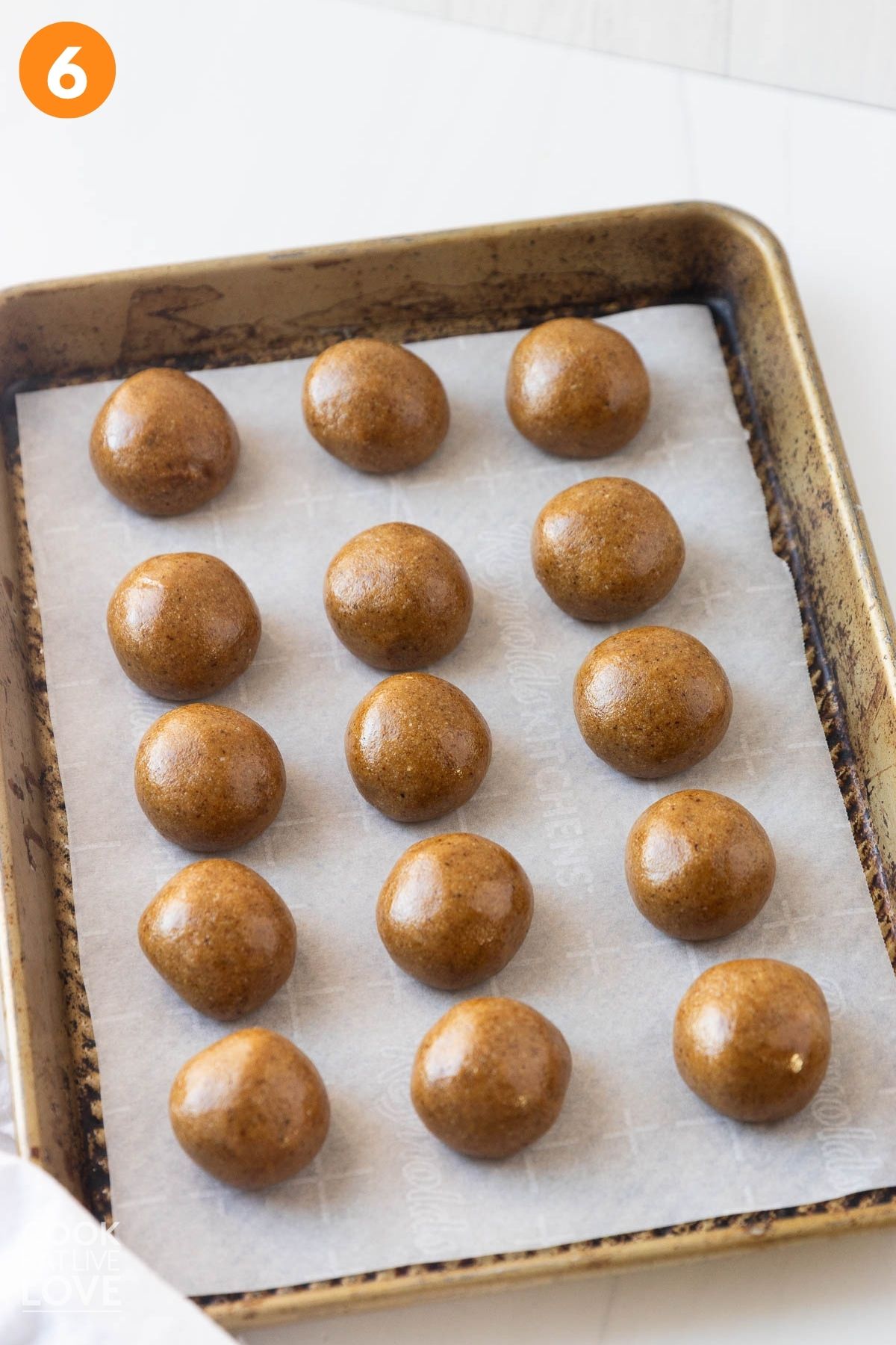 The gingerbread balls on a lined baking sheet.
