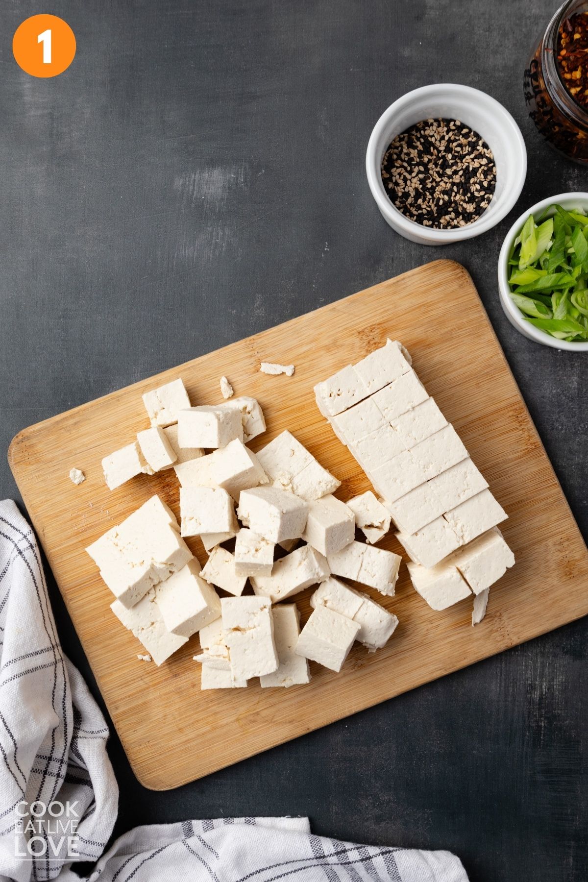 Tofu cut up into cubes on a cutting board.