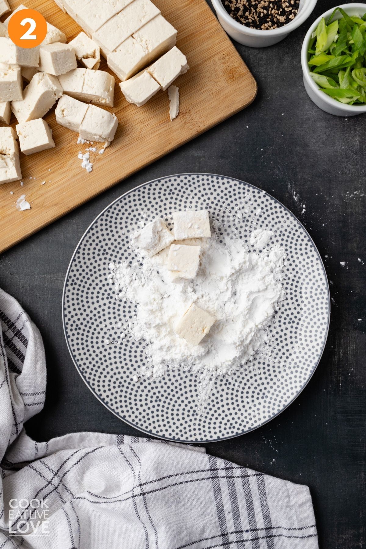 Tofu coated in cornstarch on a plate.