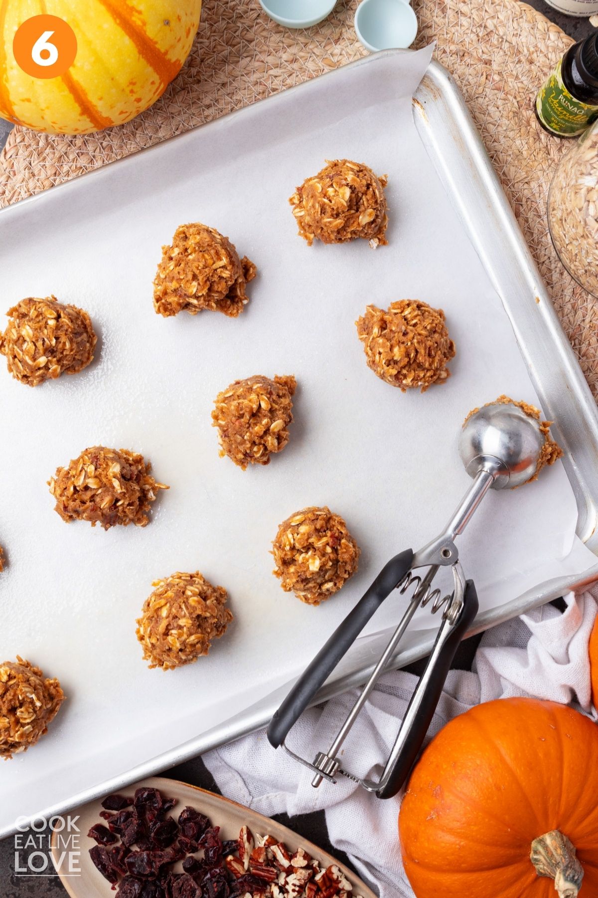 Cookie scoop portioning the dough into balls on a prepared baking sheets. 