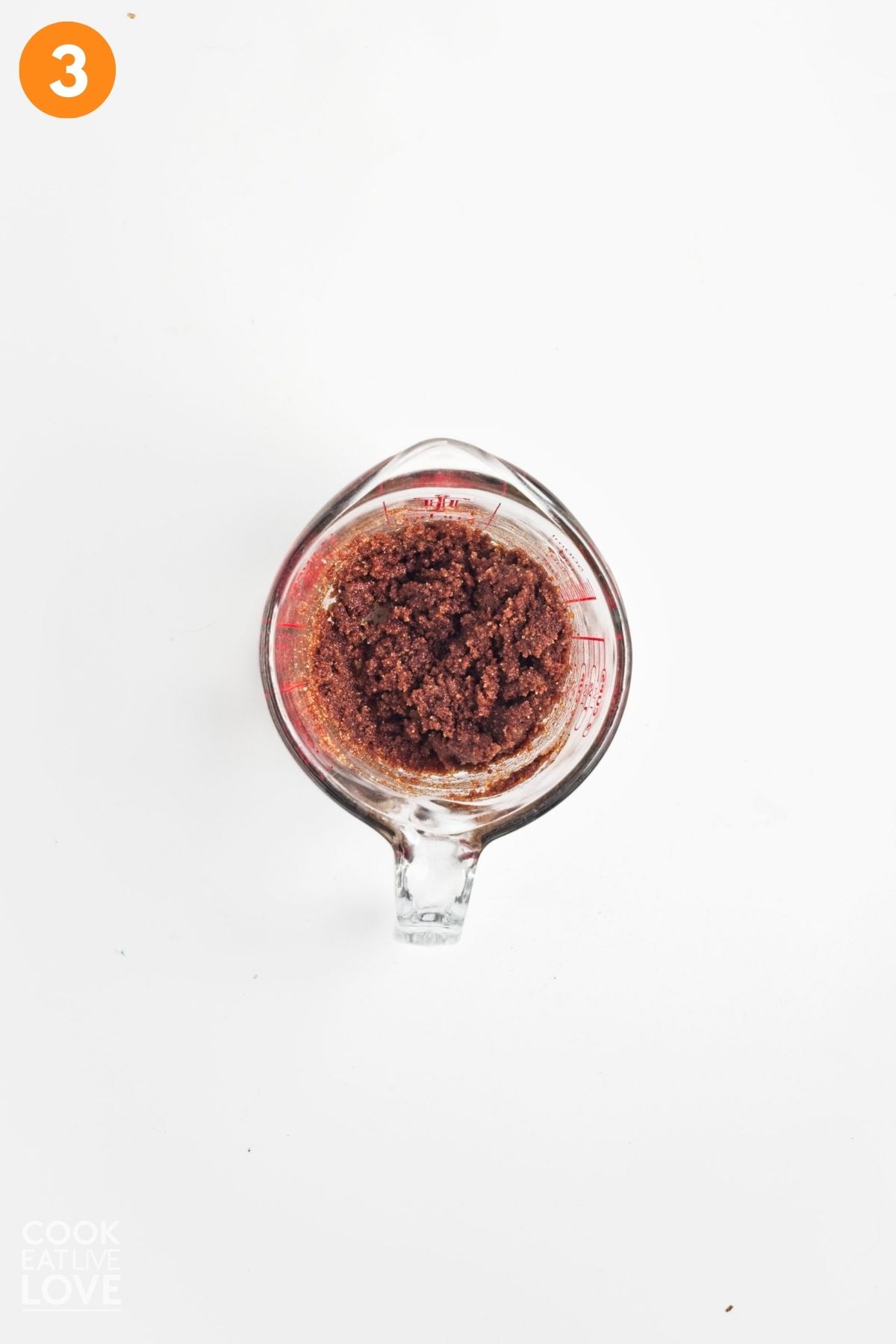 Sugar, cinnamon, and coconut oil combined in a measuring cup.