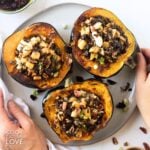 Vegetarian stuffed acorn squash on a gray plate.