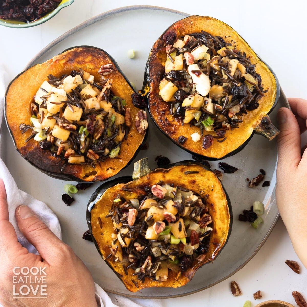 Vegetarian stuffed acorn squash on a gray plate.