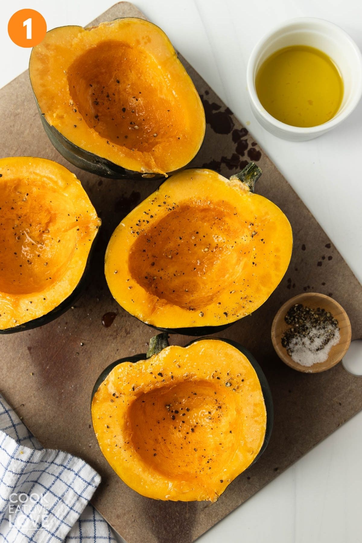 Acorn squash cut in half and brushed with olive oil and sprinkled with seasoning. 