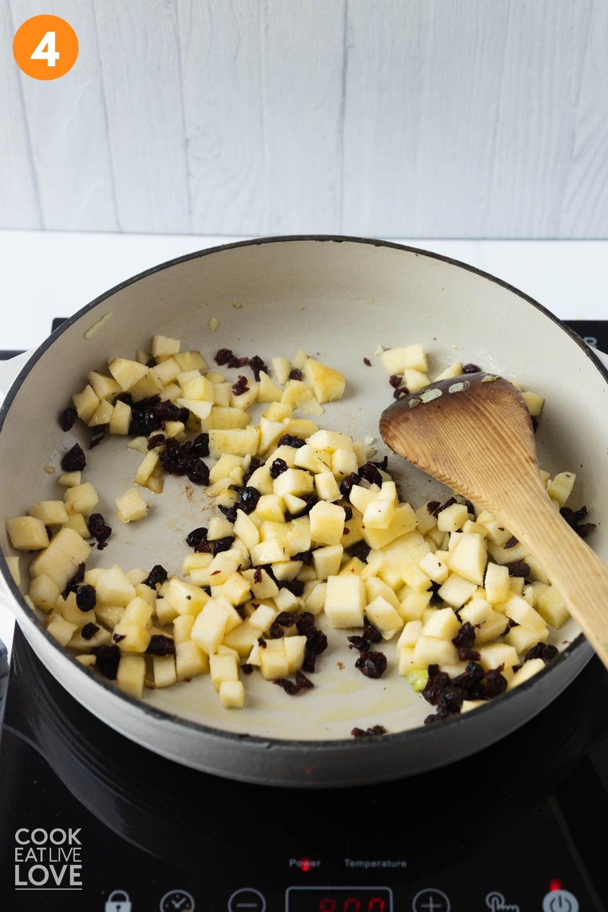Apples and cranberries cooking in a skillet. 