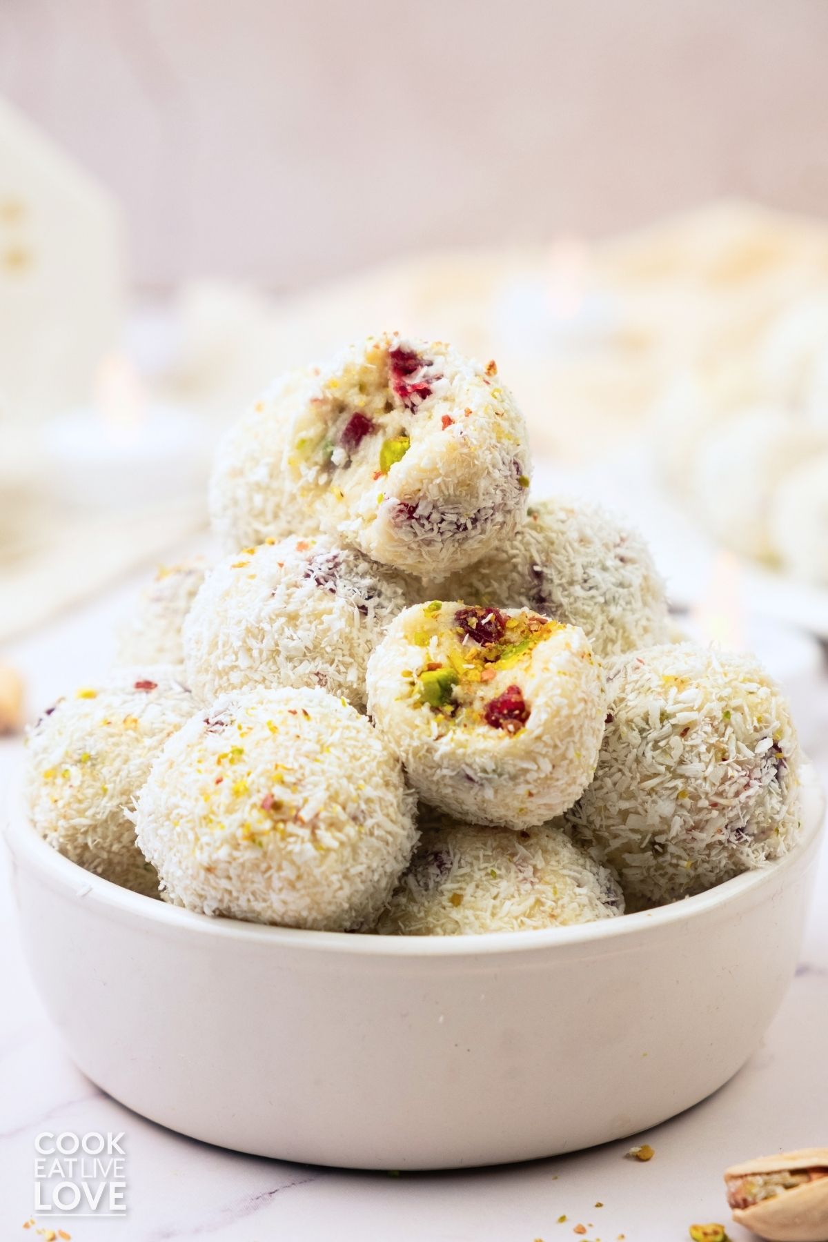 A bowl with white chocolate truffles stacked.